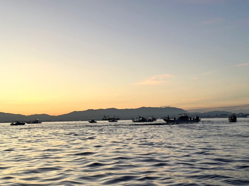 朝の博多湾の写真。タチウオ狙いの遊漁船が集まっている