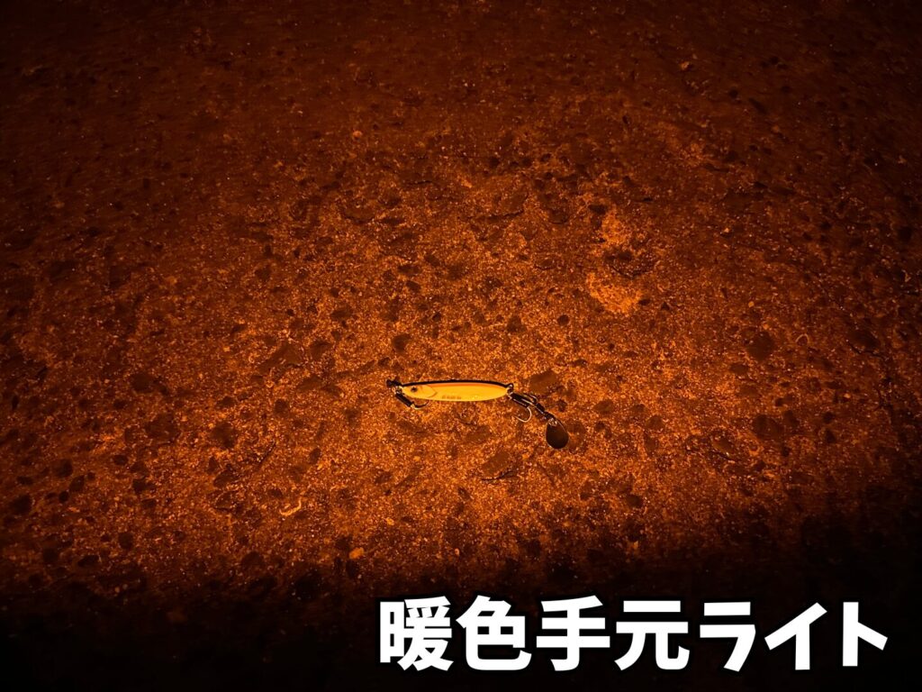 手元暖色（オレンジ）ライトでジグを照らしている画像
