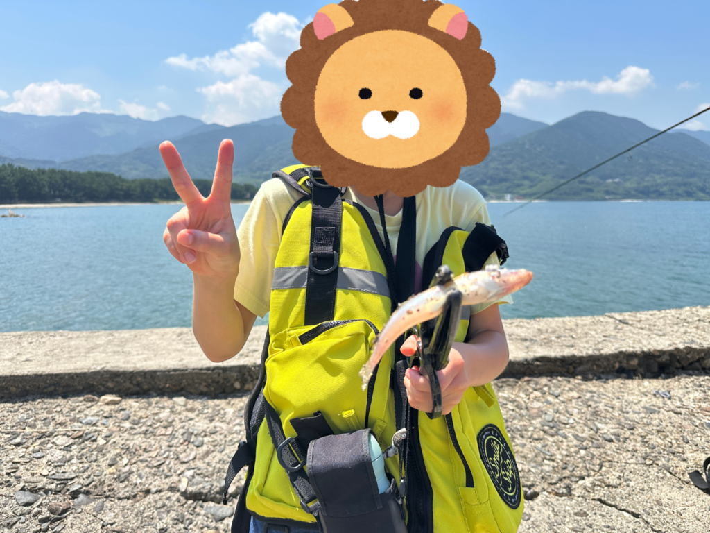 下の子どもがキスを釣った写真、ライフジャケットを着ているので暑そう