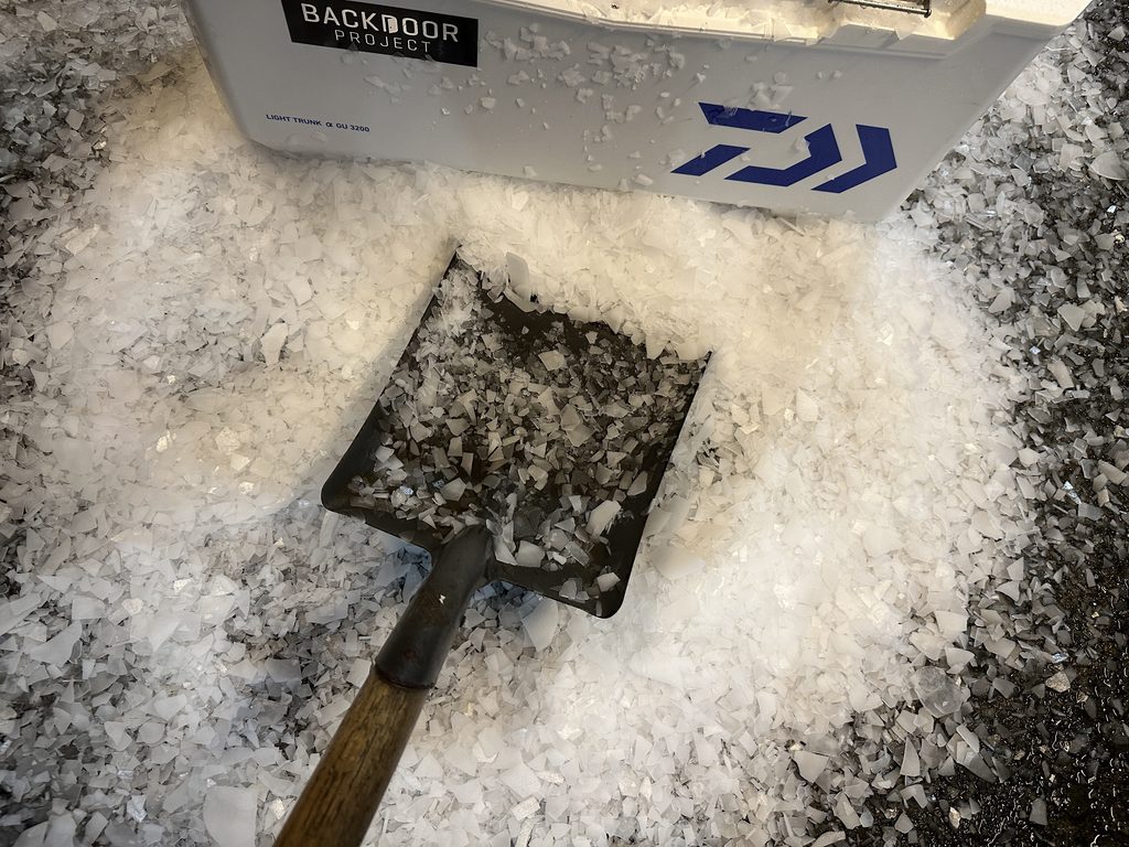 溢れた氷をスコップでクーラーボックス内に入れている様子